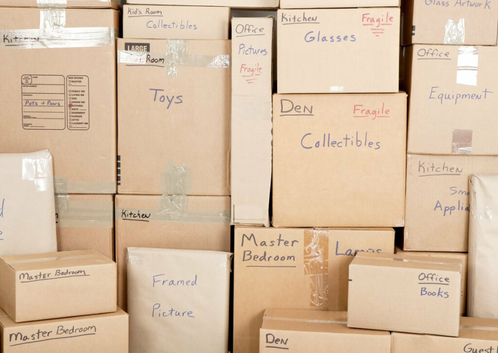 Cardboard boxes stacked up and labeled with what they contain