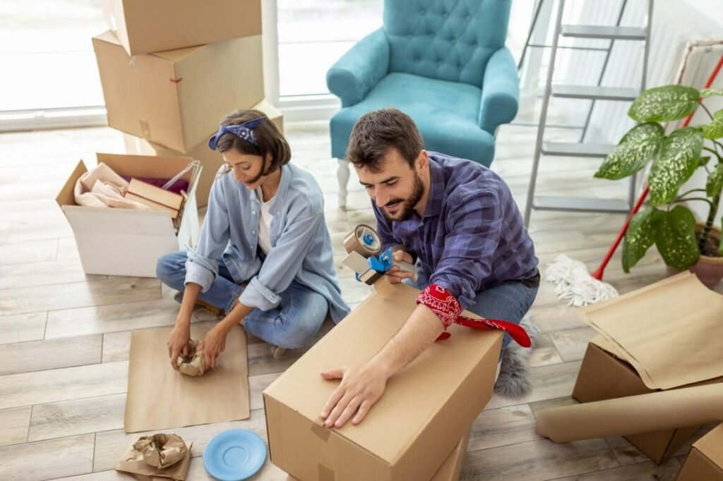 Man and woman packing items into carboard boxes