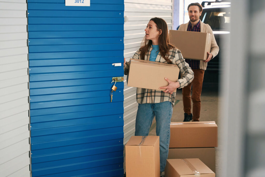 Man and woman moving boxes into a storage unit