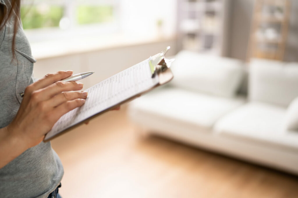 Woman making a list of her appliances on a clipboard.