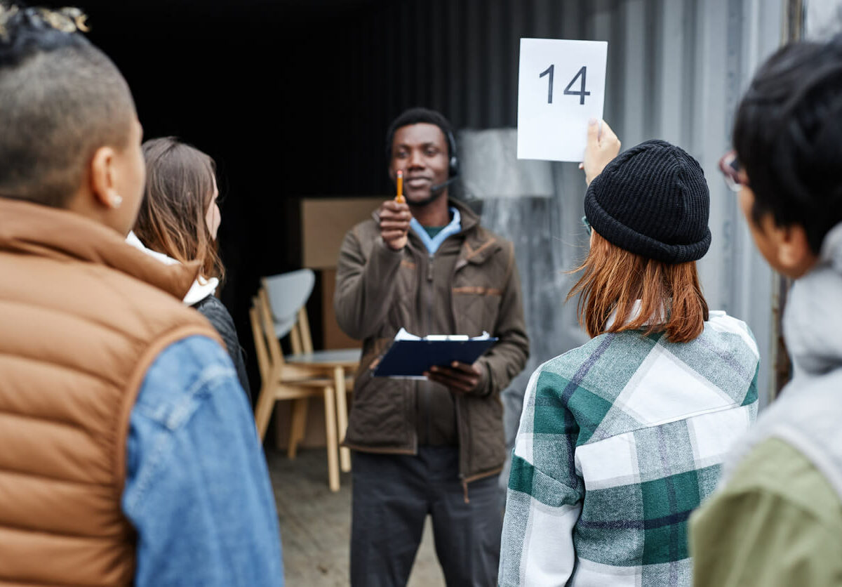 A person holding up their number at an auction to bid.