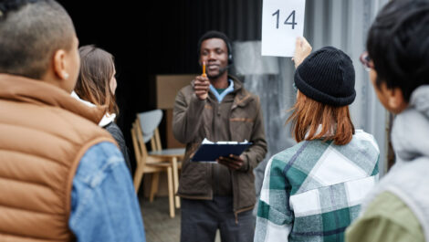 A person holding up their number at an auction to bid.