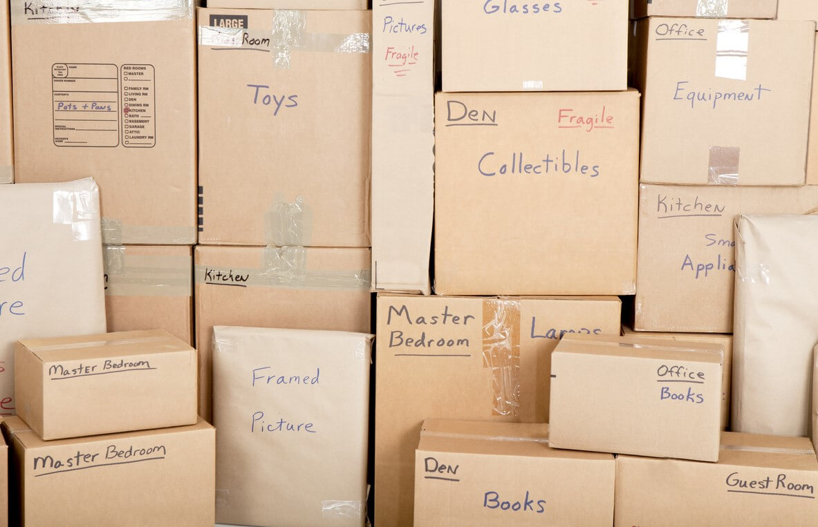 Stacks of cardboard boxes in storage with labels to tell what is inside each one.