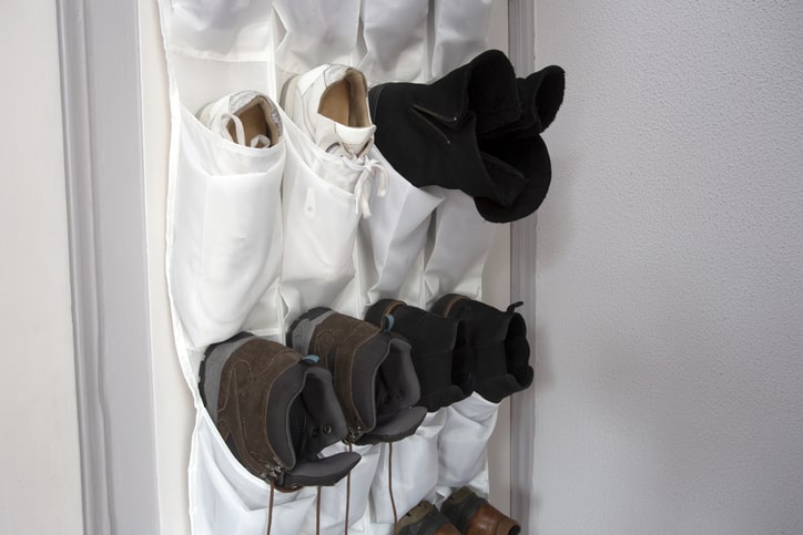 Cloth, over-the-door shoe rack filled with shoes.
