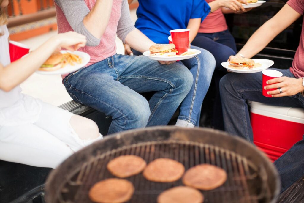 A group of Ohio State football fans eats burgers at their football tailgate party.